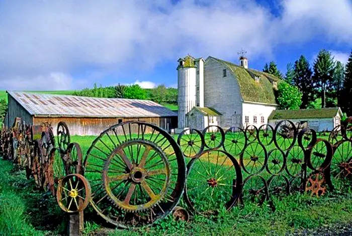 Una valla hecha de rueda de carro vieja.