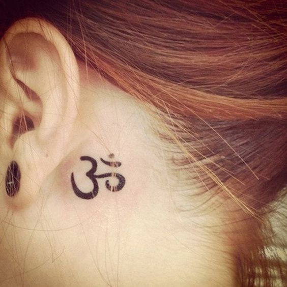 Una chica con un tatuaje detrás de la oreja con el símbolo Om: 