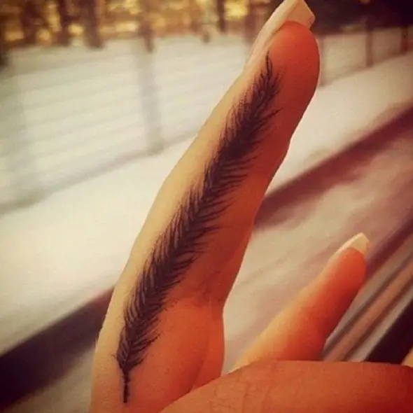 pequeño tatuaje de plumas en el dedo