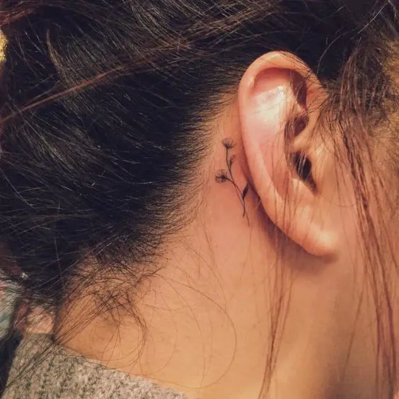 tiny flowers tattoo behind the ear: 