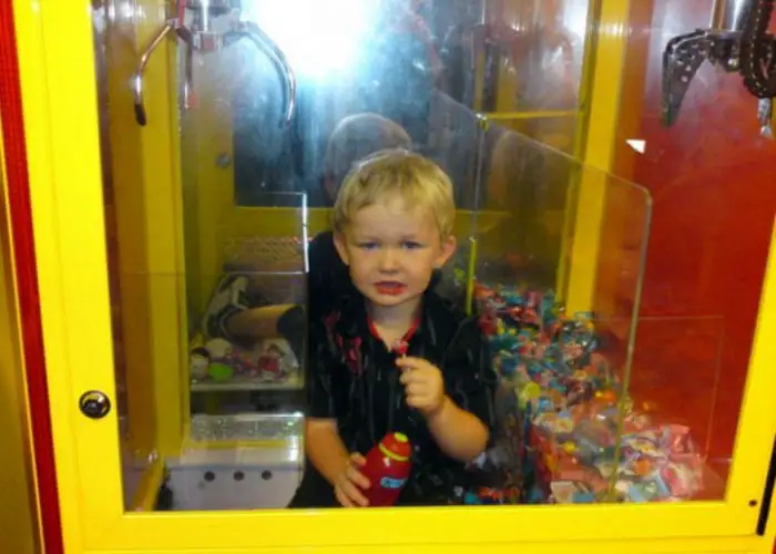 El niño en la máquina con los juguetes.