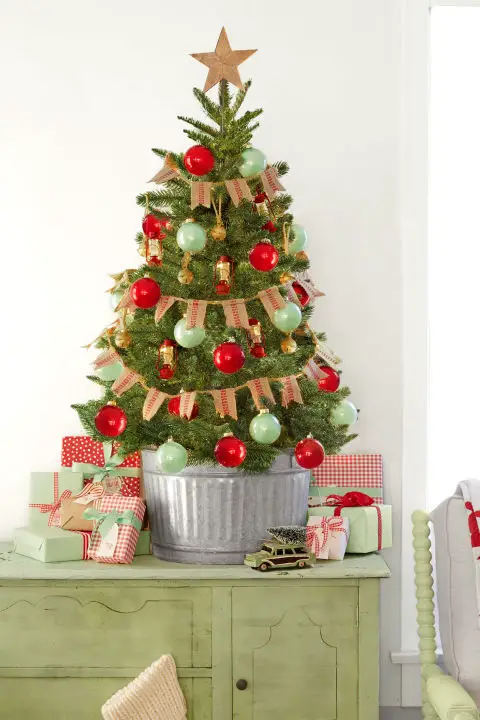 Este mini árbol de Navidad trae importantes encanto del país gracias a su bandera de arpillera, cubo galvanizado, y los ornamentos de la linterna. 