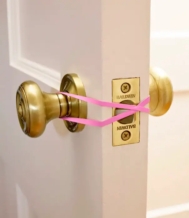 Mantener abierta una puerta con bandas de goma para proteger a sus hijos se quede encerrada en el baño