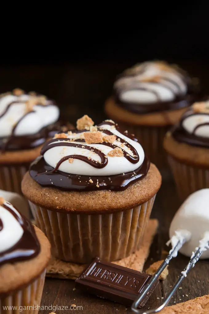 Celebrate National S'mores Day with S'mores Cupcakes that have milk chocolate ganache and fluffy marshmallow frosting on top of a graham cracker cake.