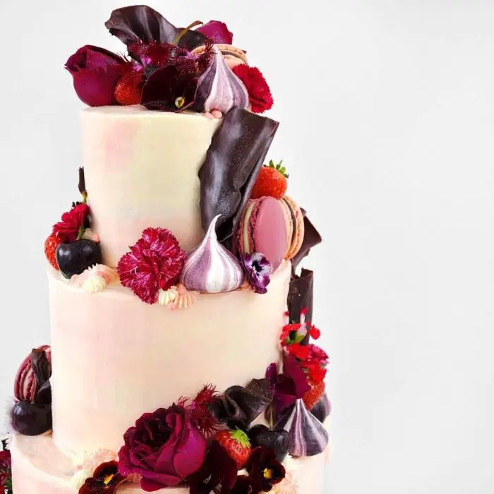 pastel rosa con blanco y flores rojas