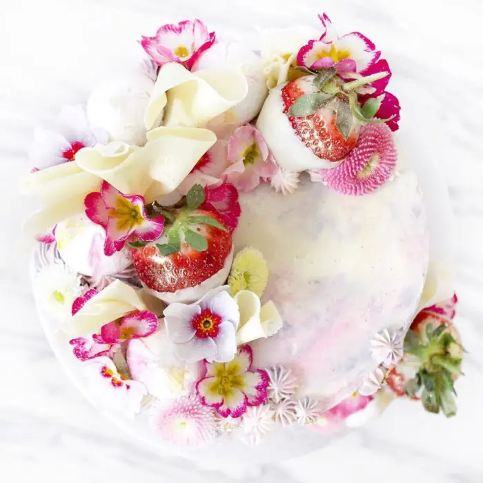 pastel blanco con flores rosas y fresas