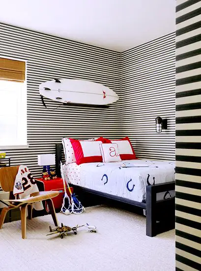21 Homes That Prove Surf Is Chic // surfboards as decor // boy's bedroom, horizontal striped wallpaper, woven blinds, Eames Lounge Chair, horseshoe bedding